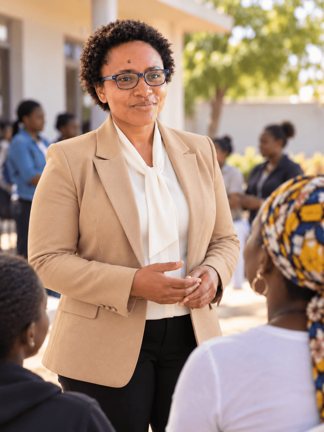 Une responsable de la Fondation échange avec un groupe de femmes, en extérieur.